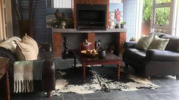 Un salon avec une cheminée, un canapé, une table basse et un téléviseur.