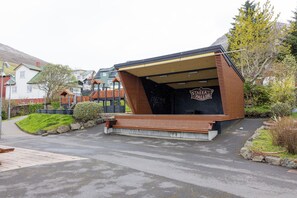 A modern building with a sloped roof and a wooden facade. - Lambastovubrekkan 6 (Sørvágur)