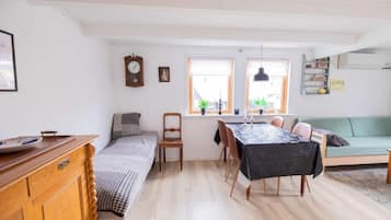 Un espacio habitable compacto con cama, mesa de comedor y sofá.
