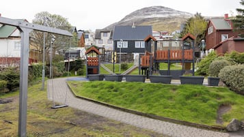 A residential area with houses, a playground, and a paved path.
