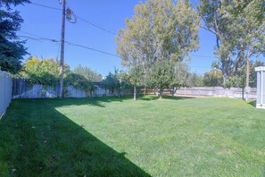 Ein Garten mit Holzparkanlage, einem Baum und blauem Himmel.