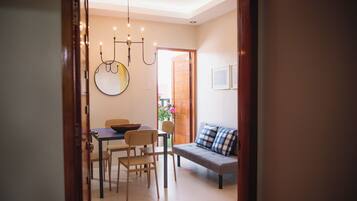 Un espace repas comprenant une table, des chaises et un luminaire suspendu.