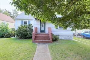 A two-story house with a front porch, a brick staircase, and a small front yard. - Studio Guest Suite Outside Baltimore (Parkville)