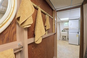 A room with wooden walls, a window, and a kitchen area with a refrigerator and washing machine. - Studio Guest Suite Outside Baltimore (Parkville)