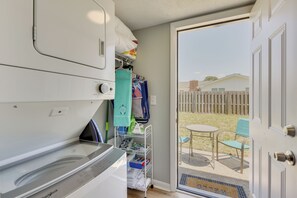 A laundry area with a washing machine and dryer, a drying rack, and a storage shelf with folded clothes. - Walk to Grand Lagoon! Couple’s Haven 2 Mi to Beach (Panama City Beach)