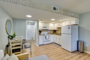 A compact kitchen with white cabinets, a microwave, an oven, and a refrigerator. - Walk to Grand Lagoon! Couple’s Haven 2 Mi to Beach (Panama City Beach)