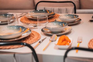 A dining table set with plates, glasses, cutlery, and a bowl of carrots. - Villa savaya 1 Antalya (Kaş)