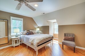 A bedroom with a bed, bedside tables, a chair, and a ceiling fan. - Deck & Yard! Tri-City Family Home Near UNC & Duke (Chapel Hill)