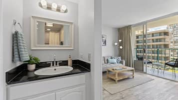 A modern bathroom with a sink, mirror, and towel rack.