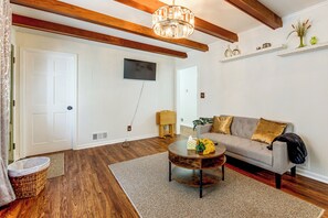 A living room with a sofa, coffee table, and a television mounted on the wall. - Atlanta Home w/ Deck, 18 Mi Outside Dtwn (Atlanta)