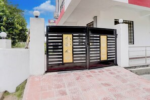 Una entrada con puerta y un camino empavedado que lleva a un edificio.