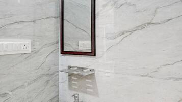 A bathroom with a white sink, a mirror, and a shower.