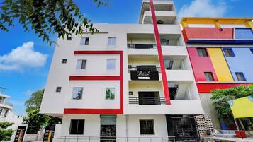 A multi-story building with a red and white facade, balconies, and a visible sign that reads 'Collection.'
