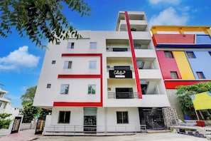 Un edificio de varios pisos con fachada roja y blanca, balcones, y un cartel que dice 'Collection'.