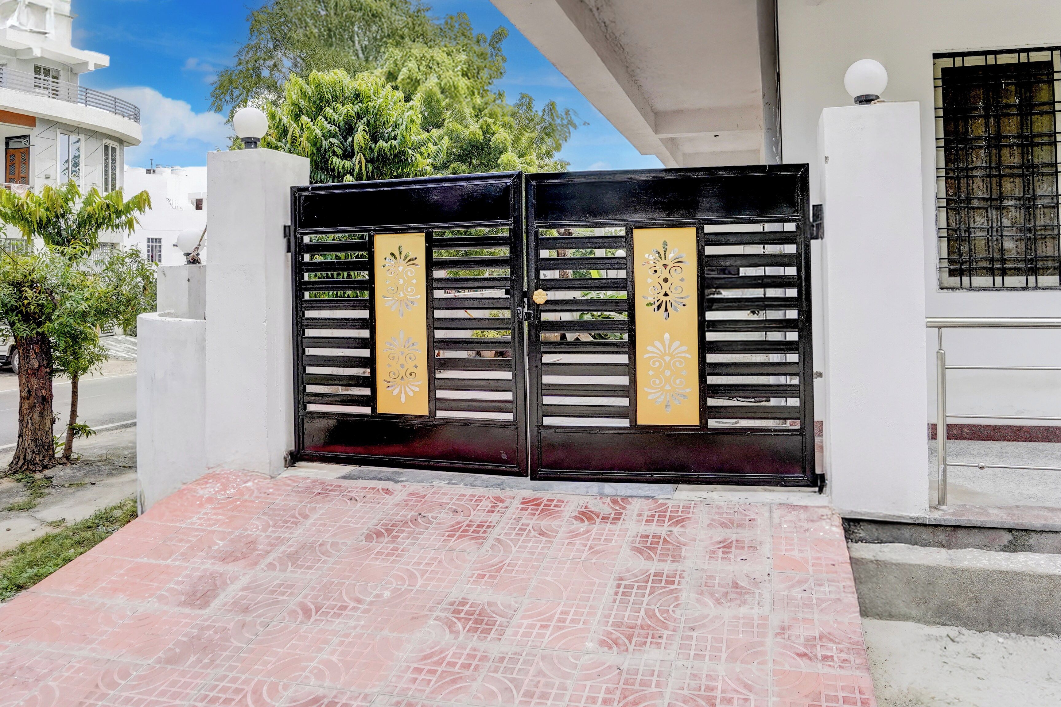 A gated entrance with a tiled pathway leading to a building.