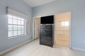 A room with a large window, a dark wooden dresser, and a door leading to another room. - Huge 4th Floor Resort Condo w/Bunk Rm near Disney (Kissimmee)