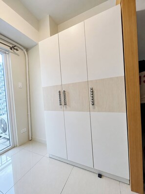 A large wardrobe with a sliding door and a wooden panel design. - Charming 2BR Apartment with Pool View in Vibrant Pasay City (Pasay City)