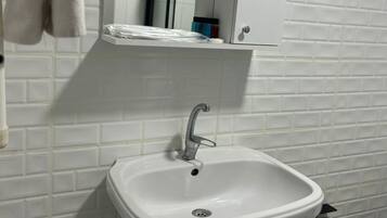 Ein Badezimmer mit einem weißen Waschbecken, einem Spiegel darüber und einer Toilette.