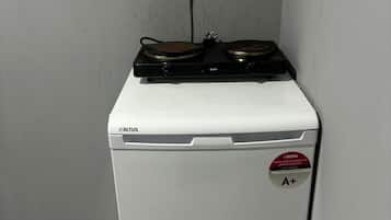 A compact, white appliance with a control panel and a rating sticker on the door.