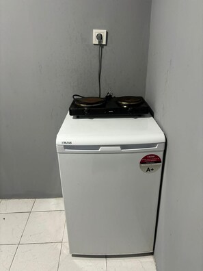 Ein kompaktes, weißes Gerät mit Bedienfeld und Kennzeichnung auf der Tür.