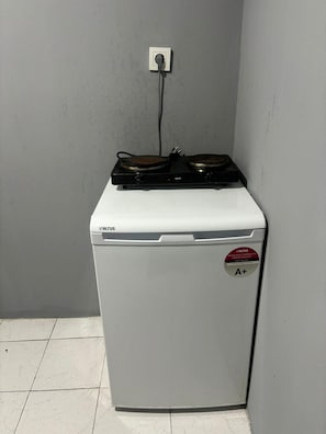 Ein kompaktes, weißes Gerät mit Bedienfeld und Kennzeichnung auf der Tür.