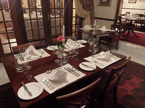 A dining area with a long table set for four, complete with plates, cutlery, and glasses. - Secluded Chalet Retreat near Kruger Park, Luxury Meets Nature, Farm living (Kiepersol)