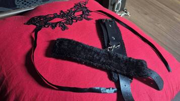 Un coussin rouge orné de dentelle noire et muni d’une bande noire.