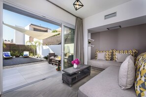 Een moderne woonkamer met een bank, salontafel en uitzicht op het buiten.