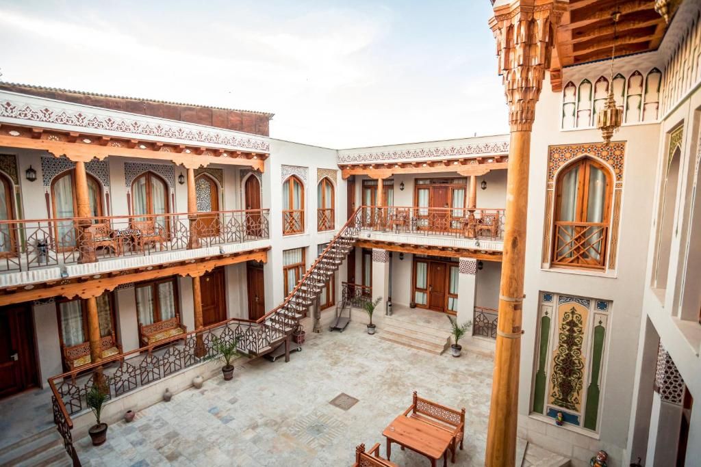 A courtyard with a central staircase, multiple balconies, and traditional wooden railings.