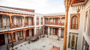 A courtyard with a central staircase, multiple balconies, and traditional wooden railings.