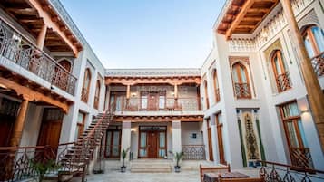A courtyard with a central staircase, balconies, and a covered seating area.