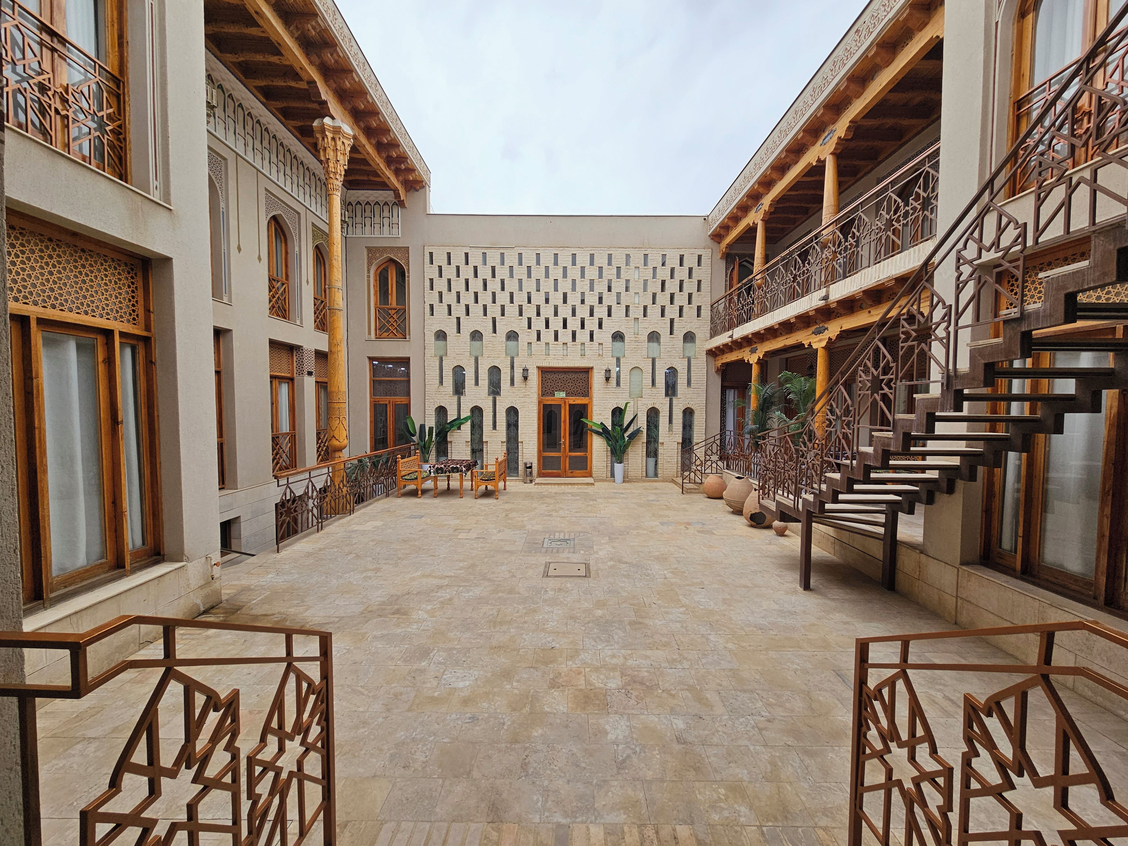 Un patio con un espacio abierto central, rodeado de edificios con elementos arquitectónicos tradicionales.