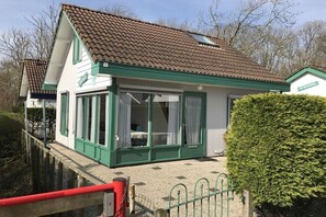 A single-story building with a sloped roof, large windows, and a green door. - Type A "Zee, Bos en Duin" Zoutelande (Zoutelande)