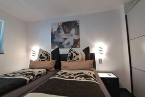 A modern bedroom with a bed, two bedside tables, and a wall-mounted artwork. - FeWo Excellence Juwel (Cochem)