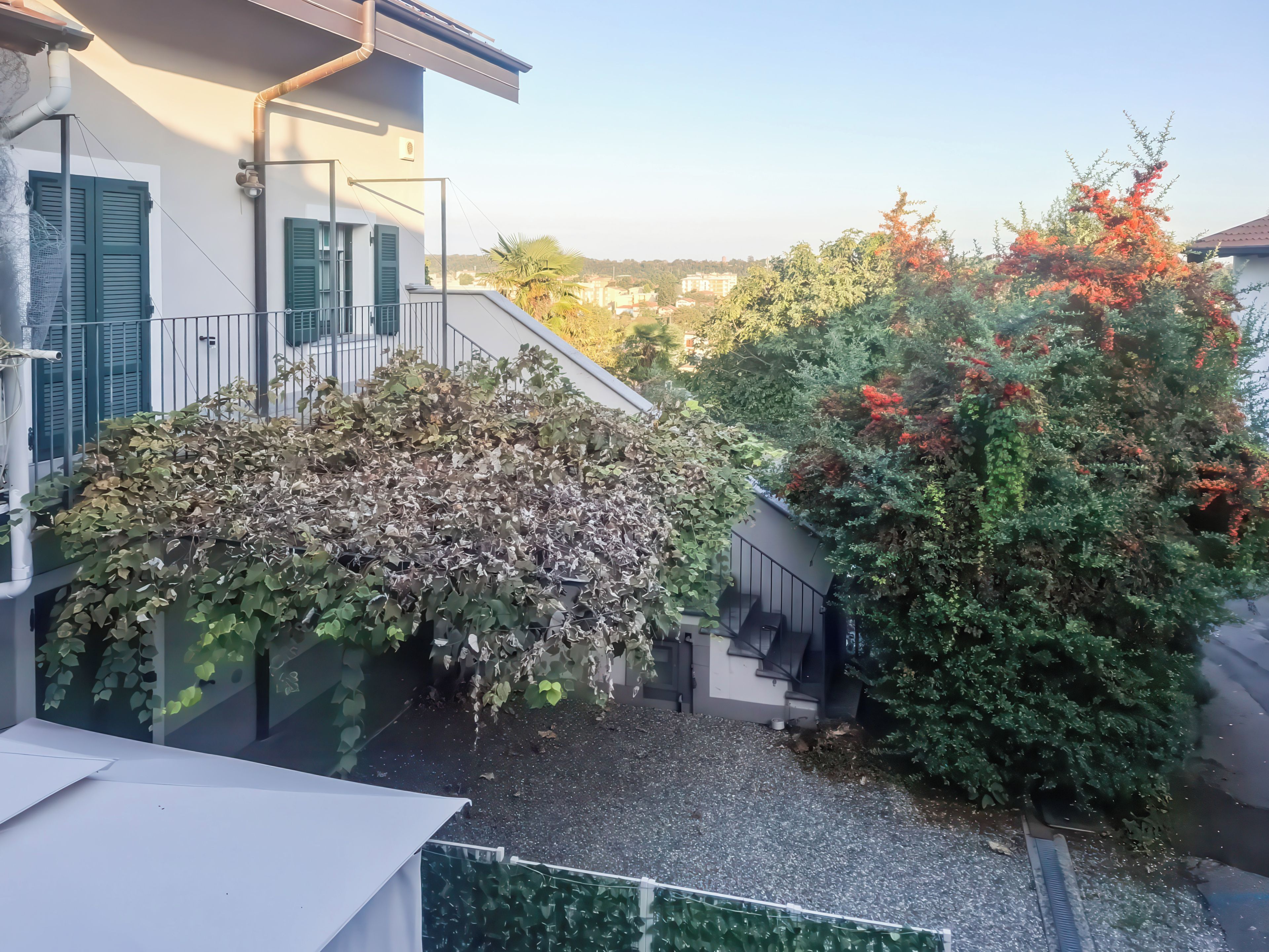 Un immeuble résidentiel doté d’un espace extérieur couvert, d’un escalier et offrant une vue sur le quartier environnant.