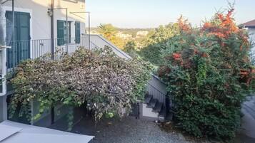 Un immeuble résidentiel doté d’un espace extérieur couvert, d’un escalier et offrant une vue sur le quartier environnant.