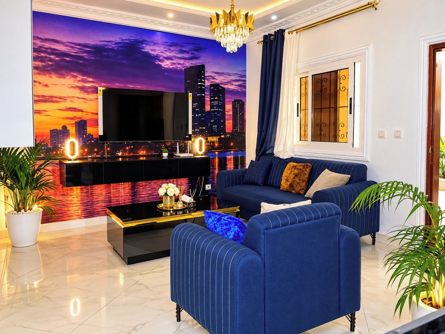 A modern living room with a cityscape mural, a flat-screen TV, a sofa, a coffee table, and a chandelier.