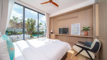 Una camera d'albergo con un letto grande, una scrivania, una televisione e vista sulla piscina e su una zona all'aperto.