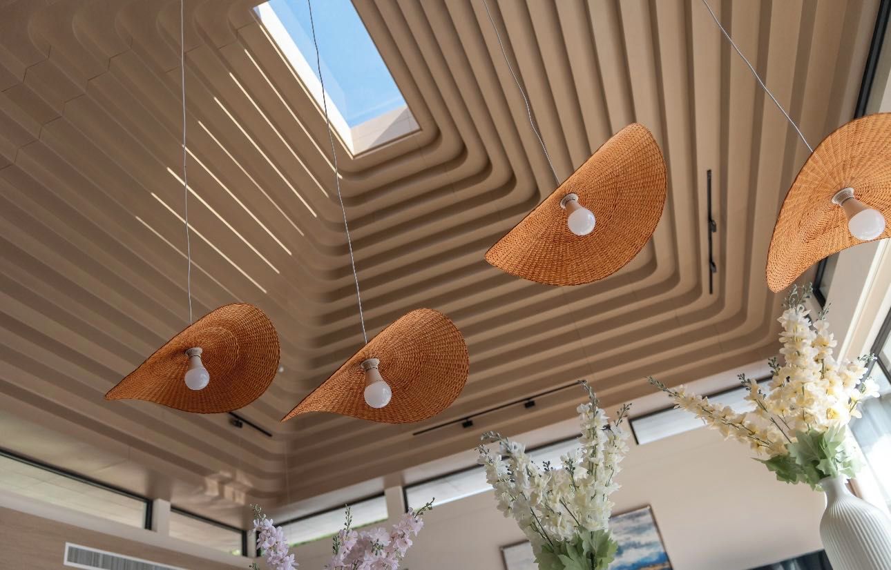 Een modern interieur met een schuine plafond, hanglampen en bloemdecoraties.