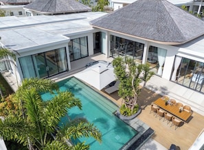 A modern residential building with a swimming pool, outdoor seating, and a covered patio area. - Kata beach 4bedroom luxury pool villa (Karon)