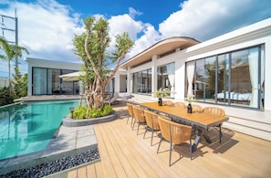 A modern house with a swimming pool, outdoor dining area, and large windows. - Kata beach 4bedroom luxury pool villa (Karon)