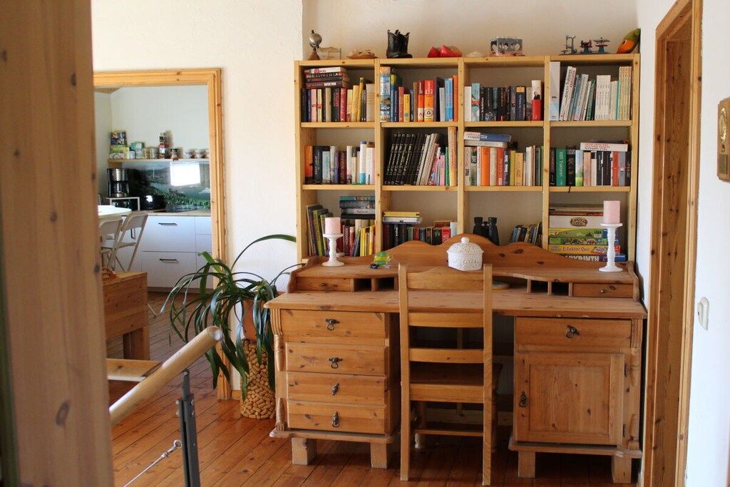 Ein Holztisch mit Bücherregal, einem Stuhl und einem kleinen Tisch.