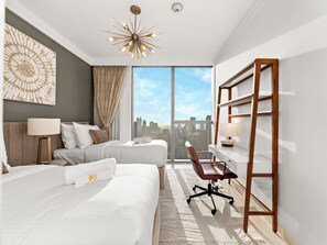 A hotel room with a large window, a bed, a desk, and a chair. - Kensington Superlex Penthouse Burj Views (Dubai)