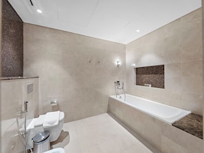 A modern bathroom with a bathtub, toilet, and shower. - Kensington Superlex Penthouse Burj Views (Dubai)