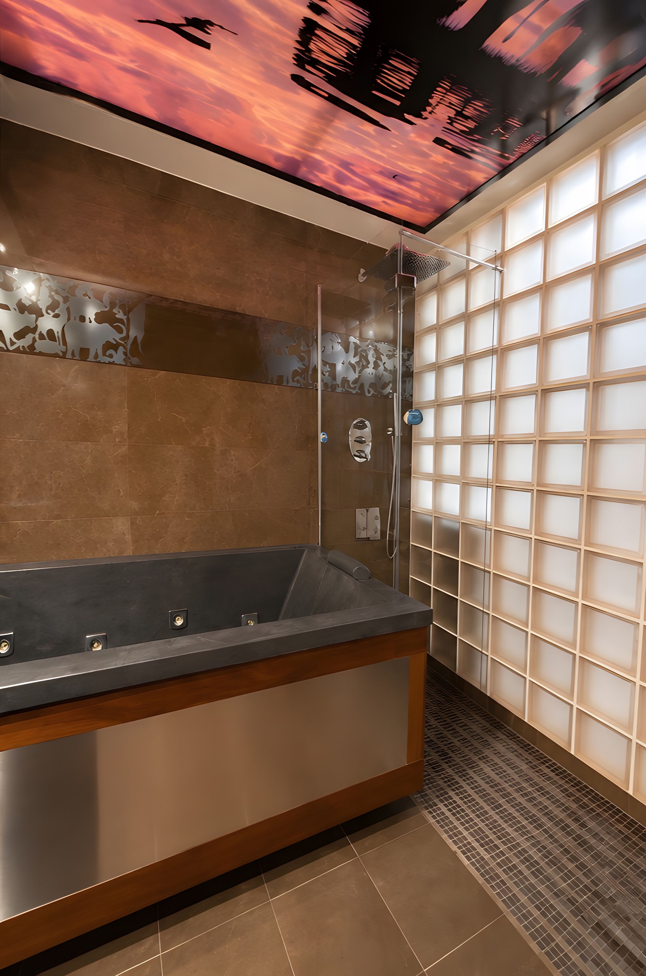 A modern bathroom with a large bathtub, a glass shower enclosure, and a decorative ceiling.