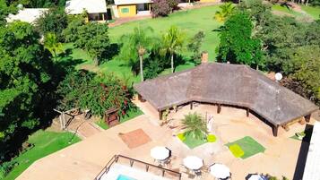 A resort with a pool, outdoor seating, and thatched-roof structures.