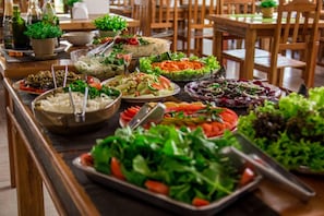 A buffet table with various dishes, including salads, rice, and other prepared foods. - Hotel Fazenda Cachoeira Serra da Bodoquena (Bodoquena)