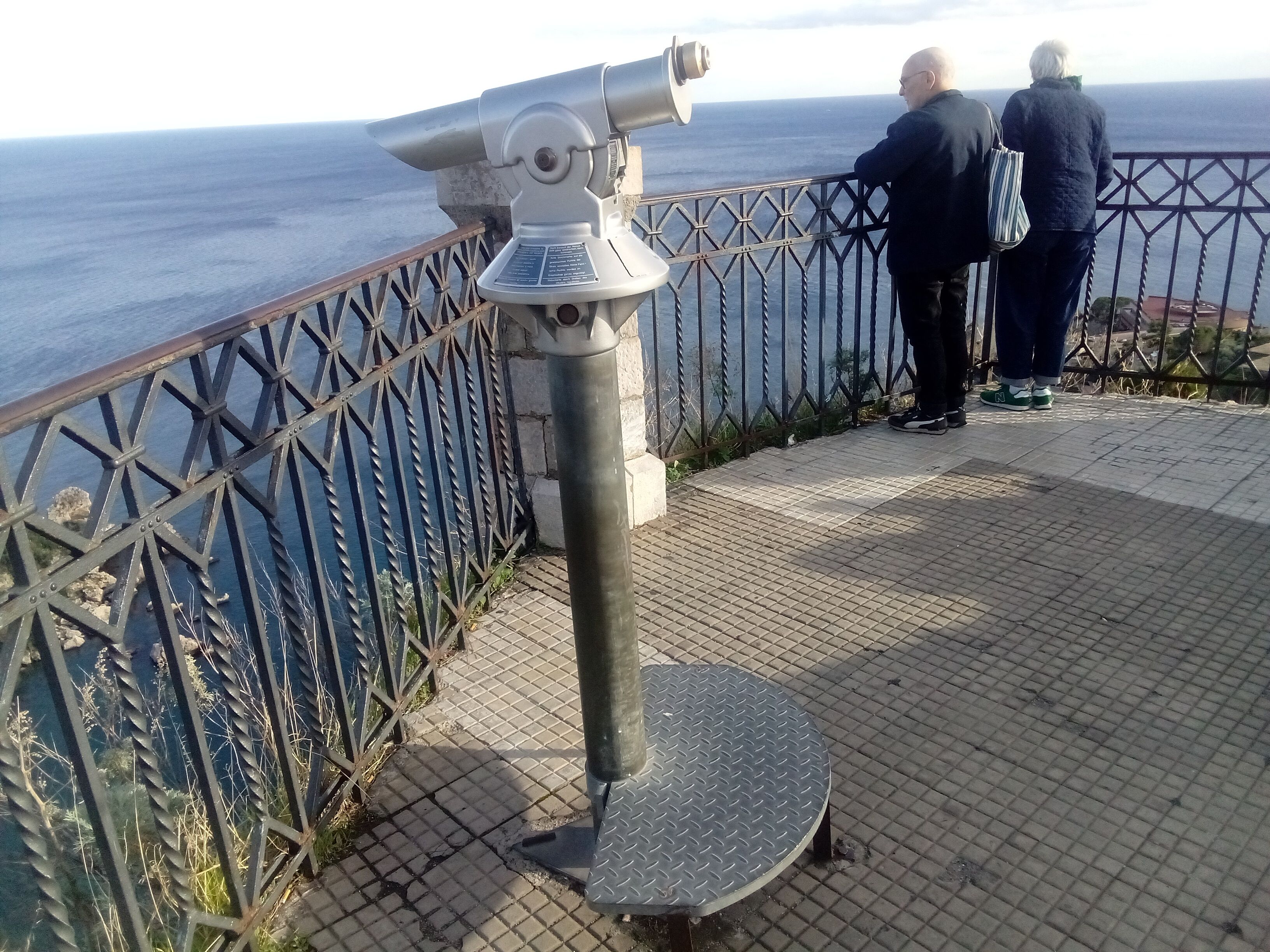 Ein Teleskop auf einer Metallplattform mit Blick auf eine Brüstung.