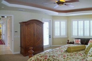 A bedroom with a bed, a wardrobe, and a ceiling fan. - Villa in Cape Coral with swimming pool (Cape Coral)