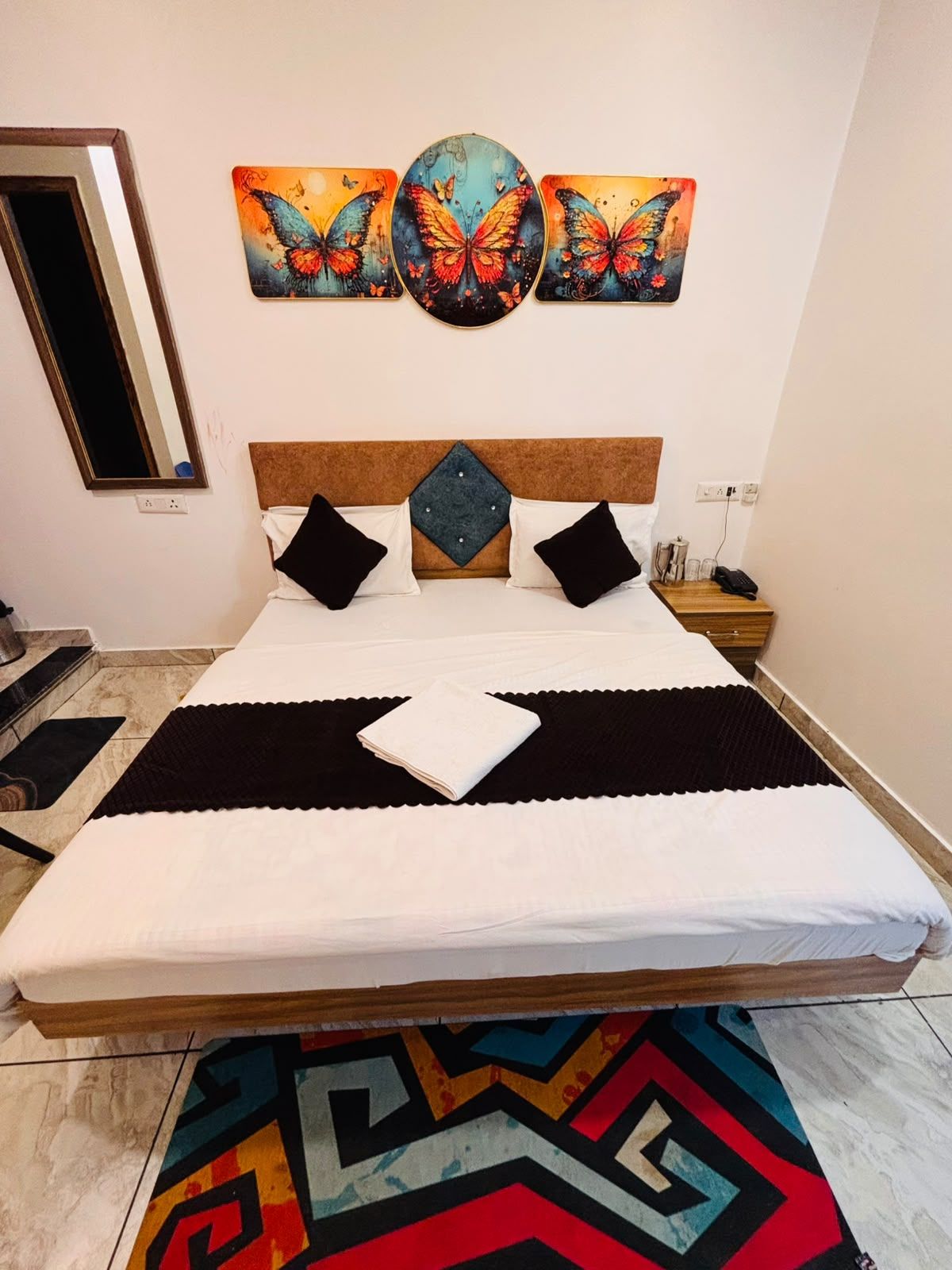 Una cama con cabecera, almohadas, una colcha y un adorno decorativo en la pared superior.